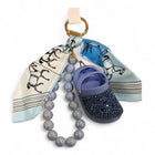 Portachiavi Tempo A Tempo con mini Crocs lilla, cristalli, foulard stampa cavalli e perle opalescenti su gancio oro.