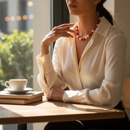 Tempo A Tempo necklace featuring white and red shell powder pearls with a gold-tone T-bar clasp worn by a woman