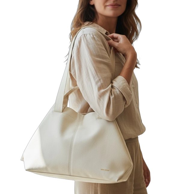 Tempo A Tempo Regina Schrecker beige faux leather shoulder bag worn by a woman in a matching linen outfit