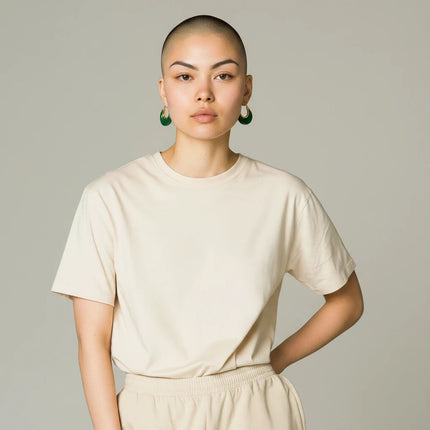 Tempo A Tempo Shelly gold-tone steel earrings with green resin worn by a model in a beige t-shirt