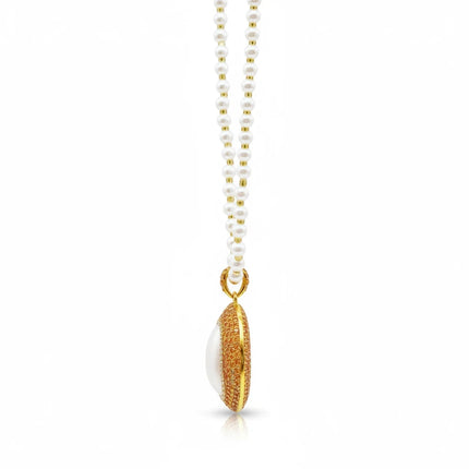 Tempo A Tempo Shelly necklace featuring white pearls and a gold oval pendant with sparkling rhinestones, side view.
