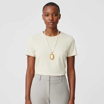 Tempo A Tempo Shelly necklace featuring white pearls and a gold oval pendant with rhinestones worn by a model