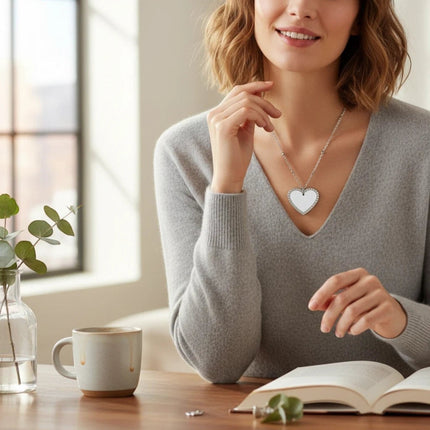Tempo A Tempo stainless steel heart pendant necklace with sparkling crystals worn by a woman in a grey sweater